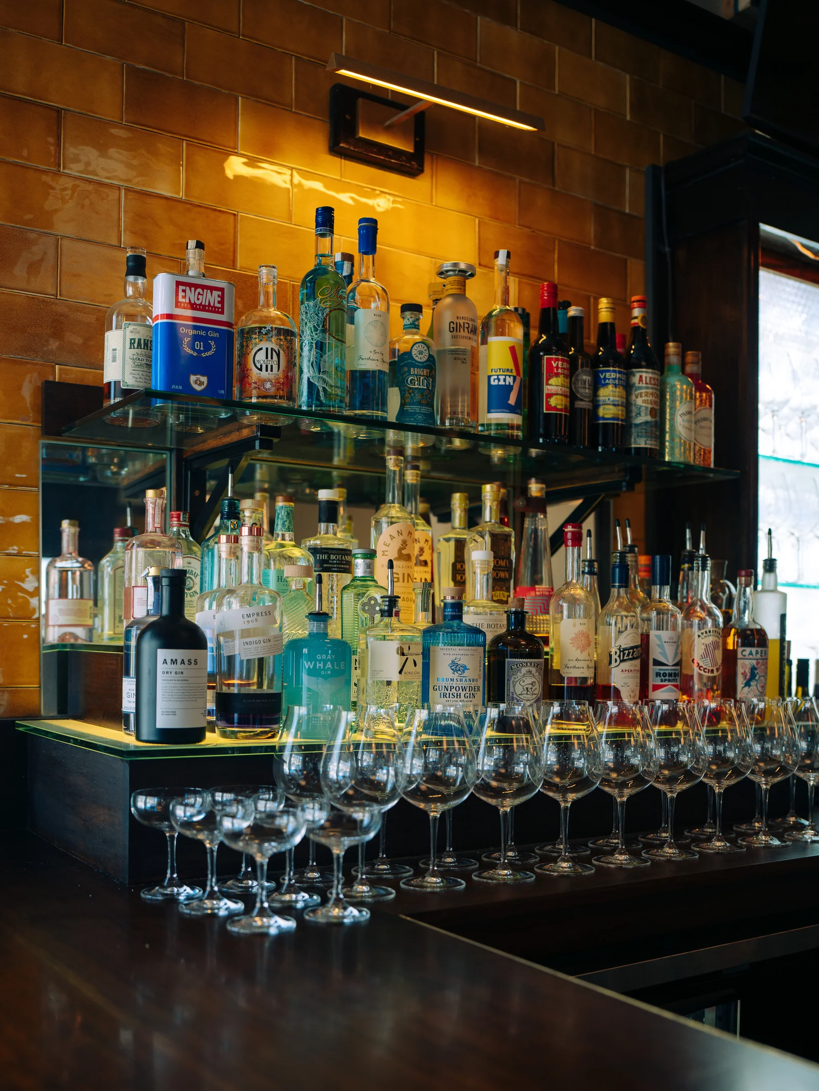Bottles and wine glasses against warm amber tiles